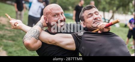 Filipino escrima arnis Instruktor und Student Practice Stick Fight Choke Techniken auf dem Kapap Martial Arts Seminar Stockfoto