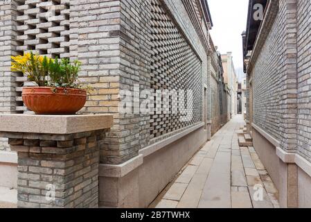 Eine typische Gasse des chinesischen Dorfes im Retro-Stil, mit Ziegelsteinhäusern und einem Pflaster aus Stein, Blume auf Topf dekoriert im Eingang, Fuzhou, Fujia Stockfoto