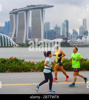 SINGAPUR - 16. FEBRUAR 2017: Menschen, die am Ufer des Flusses Singapur vor der Innenstadt von Singapur fahren Stockfoto