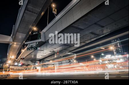Blick auf den nächtlichen Verkehrsfluss, der sich über erhöhte Autobahnen in Namba, Osaka, Japan bewegt. Stockfoto