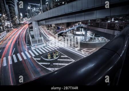 Blick auf den nächtlichen Verkehrsfluss, der unter einer Brücke über Shin Midosuji in Higashi Umeda, Osaka, Japan, vorbeiführt Stockfoto
