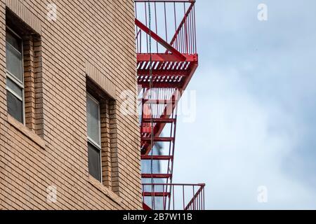 Ziegelsteine Gebäudefassaden mit Feuerlöschtreppen Stockfoto