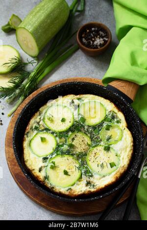 Frühstück. Sommer-Omelette mit Zucchini und Kräutern auf einem Stein- oder Schiefertisch. Stockfoto