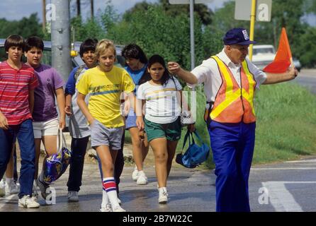 Austin, Texas, USA: Schulübergangswache, der den Fußgänger- und Fahrzeugverkehr auf dem Fußgängerüberweg vor der Schule lenkt. ©Bob Daemmrich Stockfoto
