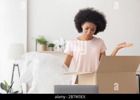 afroamerikanisches Mädchen unzufrieden mit der Lieferung aus dem Online-Shop Stockfoto