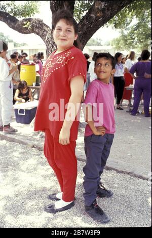 San Antonio, Texas USA, 1991: Junge und Mädchen der fünften Klasse vergleichen die Höhen auf dem Schulhof und zeigen, wie sich gleichaltrige Kinder zu verschiedenen Zeiten entwickeln. ©Bob Daemmrich Stockfoto