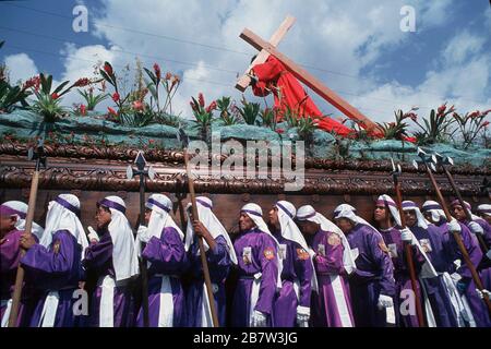 Antigua, Guatemala: Männer tragen in passenden Kostümen einen Festwagen (anda) während einer Karwoche (Semana Santa) Prozession, die bis zum Ostersonntag ©Bob Daemmrich führt Stockfoto