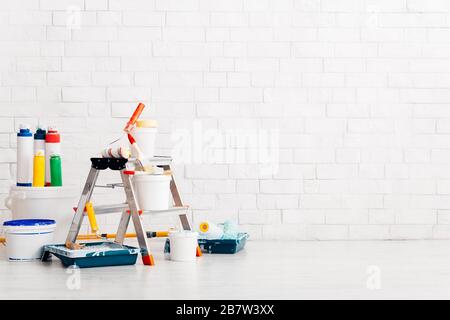 Wand bei Renovierung mit Leiter und Farbkeimer im leeren Raum Stockfoto