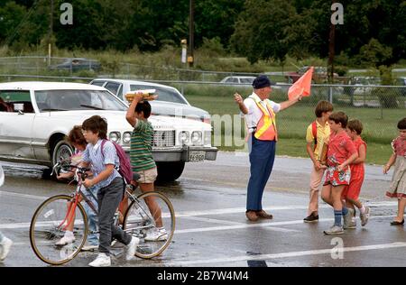 Austin, Texas USA: Schulübergangswache, die den Fußgänger- und Fahrzeugverkehr auf dem Fußgängerüberweg vor der Grundschule leitet. ©Bob Daemmrich Stockfoto