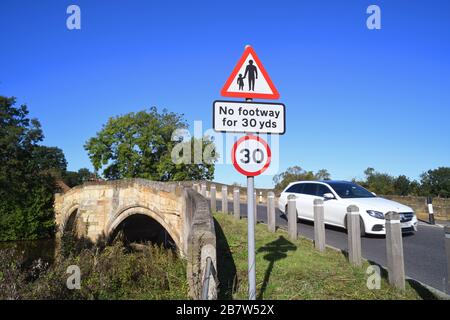 LKW, der keinen Fußraum für Fußgänger in vorausfahrender Straße passiert, Warnschild auf der Brücke, die den Fluss derwent in sutton auf derwent united überquert Stockfoto