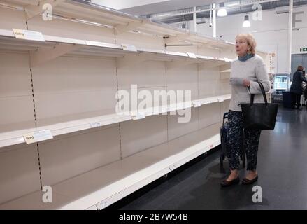 Eine Frau sieht sich leere Regale in einem Sainsbury's Store in London an, da Coronavirus weiterhin Großbritannien betrifft, wobei die Zahl der Todesopfer im Vereinigten Königreich 71 Personen erreicht. Stockfoto