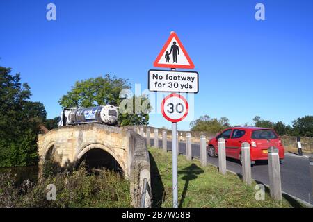 LKW, der keinen Fußraum für Fußgänger in vorausfahrender Straße passiert, Warnschild auf der Brücke, die den Fluss derwent in sutton auf derwent united überquert Stockfoto