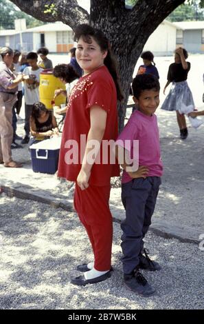 San Antonio, Texas USA, 1991: Junge und Mädchen der fünften Klasse vergleichen die Höhen auf dem Schulhof und zeigen, wie sich gleichaltrige Kinder zu verschiedenen Zeiten entwickeln. ©Bob Daemmrich Stockfoto