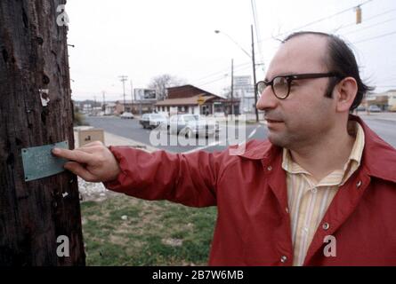 Austin Texas USA: Sehbehinderter Mann, der in Blindenschrift auf öffentlichen Bereichen ein Schild verwendet, um zu navigieren. ©Bob Daemmrich Stockfoto