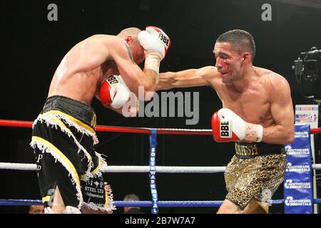 Ben Jones (schwarze/gelbe Shorts) besiegt Akaash Bhatia (Goldshorts) in einem Super-Featherweight-Boxwettkampf um den englischen Titel im Medway Park, Gill Stockfoto