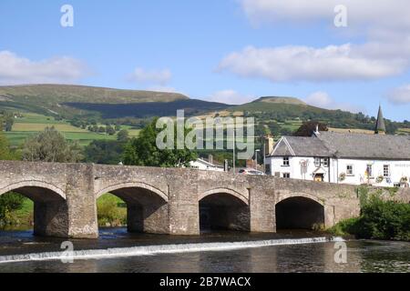 Die Brücke der Kategorie 1, die über einem Wehr über den Fluss Usk, Crickhowell, Powys, Wales, Großbritannien steht, aus dem 18. Jahrhundert Stockfoto