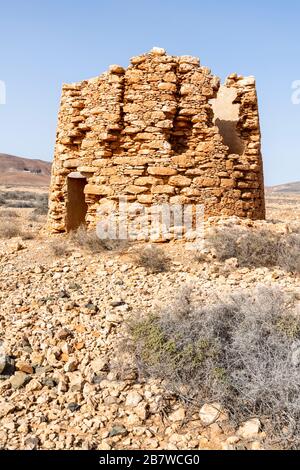 Die Ruinen einer alten Windmühle aus Stein, die früher zur Grundwasseraufhebung für die Bewässerung in der Nähe von Tuineje im Zentrum der Kanareninsel Fuerteventura diente Stockfoto