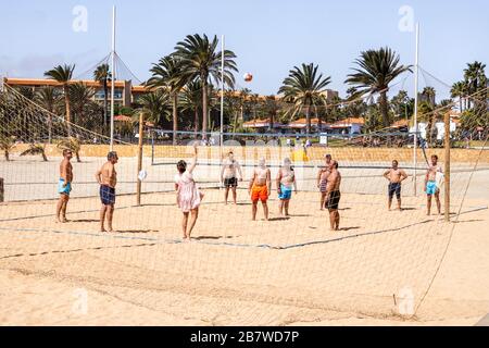 Ein Spiel mit Beachvolleyball an einem Sonntagnachmittag an der Küste von Caleta de Fuste an der Ostküste der Kanareninsel Fuerteventura Stockfoto