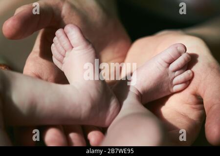 Mutter hält die Feets des neugeborenen Babys. Stockfoto