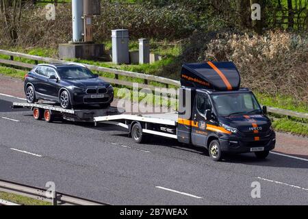 Iveco Pro Fahrer Lieferwagen, die BMW-Anhänger, Lastwagen, Transport, LKW, Frachtführer, Fahrzeug, europäischer kommerzieller Transport, Industrie, M61 in Manchester, Großbritannien schleppen Stockfoto