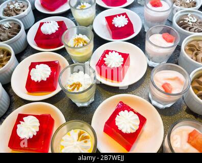 Verschiedene Desserts (Schokoladenmousse, Erdbeergelee mit weißer Mousse, Panna Cotta mit weißer Mousse) in der Dessertbar des Restaurants. Stockfoto
