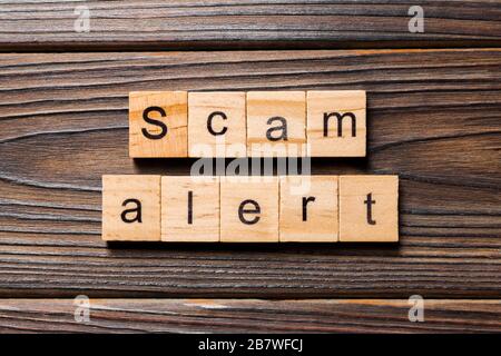 Scam alert Wort auf Holz Block geschrieben. Scam alert Text auf Tisch, Konzept. Stockfoto