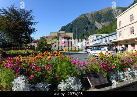 Blick auf Juneau, Alaska Downtown mit Blumen im Hintergrund, Franklin Street mit Autoverkehr und Touristen. Sonniger Tag im Sommer Alaska, USA. Stockfoto