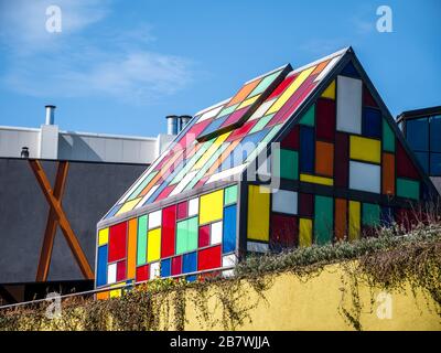 Kleines Haus aus farbigem Glas mit blauem Himmel im Hintergrund. Stockfoto