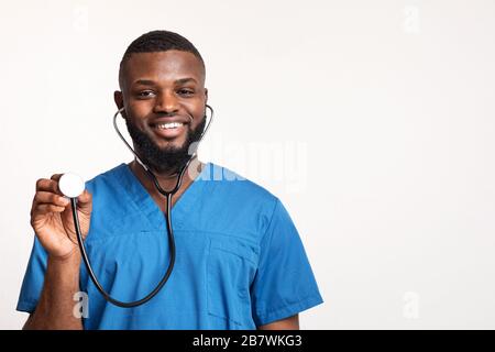 Fröhlicher afrikanischer Arzt bereit, den Patienten zu untersuchen Stockfoto
