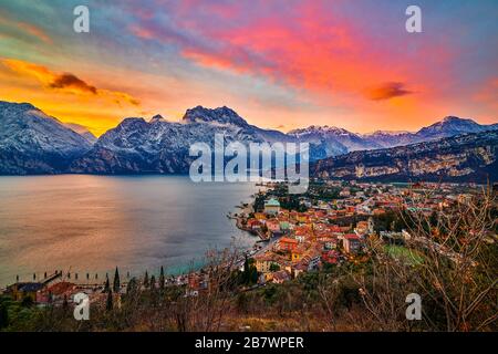 Wunderschönes Panorama in der Torbole eine kleine Stadt am Gardasee im Winter bei Sonnenuntergang, Gardasee umgeben von Bergen, Trentino Alto Adige RE Stockfoto