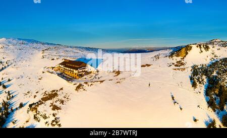 Dochia Chalet und Toaca Peak bei Sonnenaufgang in den Ceahlău Mountains National in der Wintersaison, Luftwinterlandschaft Stockfoto