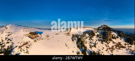 Dochia Chalet und Toaca Peak bei Sonnenaufgang in den Ceahlău Mountains National in der Wintersaison, Luftwinterlandschaft Stockfoto