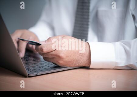 Unternehmer halten Kreditkarte und benutzen Laptop. Online-Shopping-Konzept Stockfoto