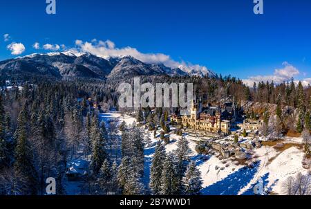 Luftdrone mit Panoramablick auf ein wunderschönes Schloss Peles in Sinaia in der Wintersaison, Siebenbürgen, Rumänien Stockfoto