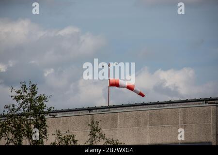 Rot-weißer Windbock auf dem Dach des Gebäudes Stockfoto
