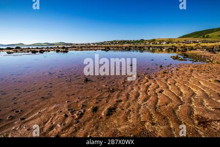 Der bunte Strand Firth of Clyde bei Ebbe in der Nähe des malerischen Dorfes Seamil, Schottland am späten Nachmittag an einem klaren Sommertag. Stockfoto