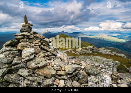 Cairn markiert den Gipfel des Ben vorlich mit der malerischen Landschaft der schottischen Highlands im Hintergrund. Stockfoto