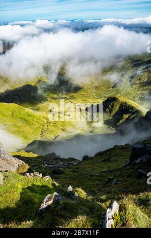 An einem Sommertag können Sie den Coire Gaothach von der Spitze von Ben Lui aus durch die Wolken betrachten. Stockfoto