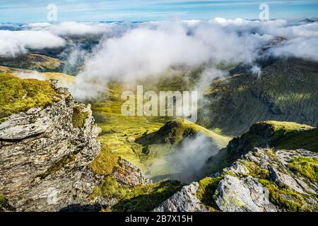 An einem Sommertag können Sie den Coire Gaothach von der Spitze von Ben Lui aus durch die Wolken betrachten. Stockfoto
