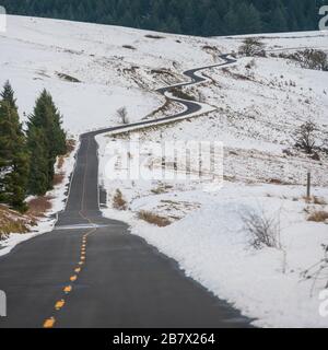 Die Straße durchschneidet Snowy Hill Side in kalifornischen Ausläufern Stockfoto