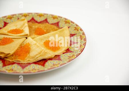 Schöne Platte mit Pfannkuchen und Kaviar mit Nahaufnahme auf weißem Hintergrund Stockfoto