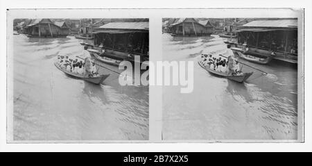 Der Fluss Stung Sangkae in der Provinz Battambang in Kambodscha. Cham Schuljungen, die in einem traditionellen Wassertaxi transportiert werden. Schwimmhallen bieten ihre Waren an. Stereoskopisches Foto von etwa 1910. Bild auf trockener Glasplatte aus der Sammlung Herry W. Schaefer. Stockfoto