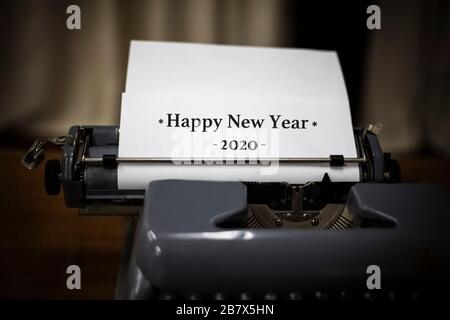 Alte Schreibmaschine mit weißem Blatt und Text GLÜCKLICH ÜBER DAS NEUE JAHR 2020. Urlaubskonzept. Platz für Ihren Text Stockfoto