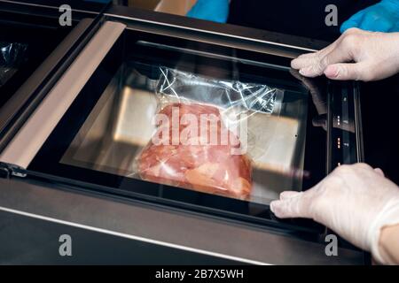 Rohes Fleisch in einem Vakuumpaket. Evakuierung von Fleisch im Vakuum. Nahaufnahme Stockfoto