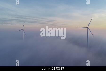 Sieversdorf, Deutschland. März 2020. Im Windpark "Odervorland" im Landkreis Oder-Spree ragen Windkraftanlagen aus dem Nebel. Derzeit gibt es im Land Brandenburg rund 3820 Windkraftanlagen mit einer Leistung von 7100 Megawatt. Credit: Patrick Pleul / dpa-Zentralbild / ZB / dpa / Alamy Live News Stockfoto