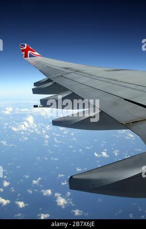 Boeing 747-400 (744) in der Flugansicht des Flugzeugflügels durch Fenster Stockfoto