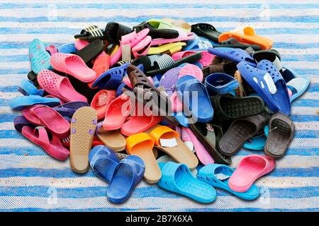 Schuhhaufen, die in verschiedenen Farbkombinationen verkauft werden, ländlicher Landmarkt, Sandalen, lockere Schuhe, alt. Stockfoto