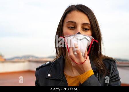 Frau, die eine Arztmaske aufsetzt. Atmung der medizinischen Atmungsmaske. Virenschutz. Stockfoto