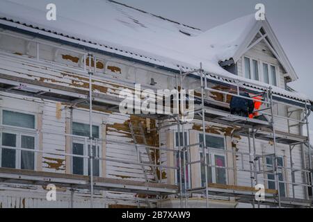 Die Arbeit an einem Haus in Tromso geht trotz des Schnees, Norwegen, weiter. Stockfoto