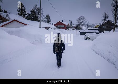 Alleinstehende Frauen, die auf der schneebedeckten Straße in Tromso, Norwegen, spazieren gehen. Stockfoto